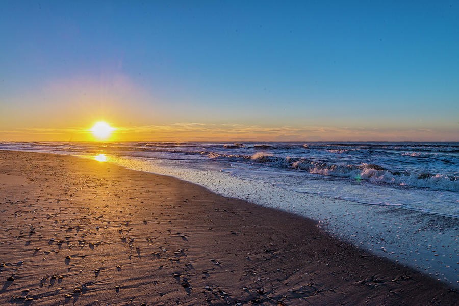 Sunrise at Atlantic Beach, North Carolina, with golden light across the sand and waves along the shore.